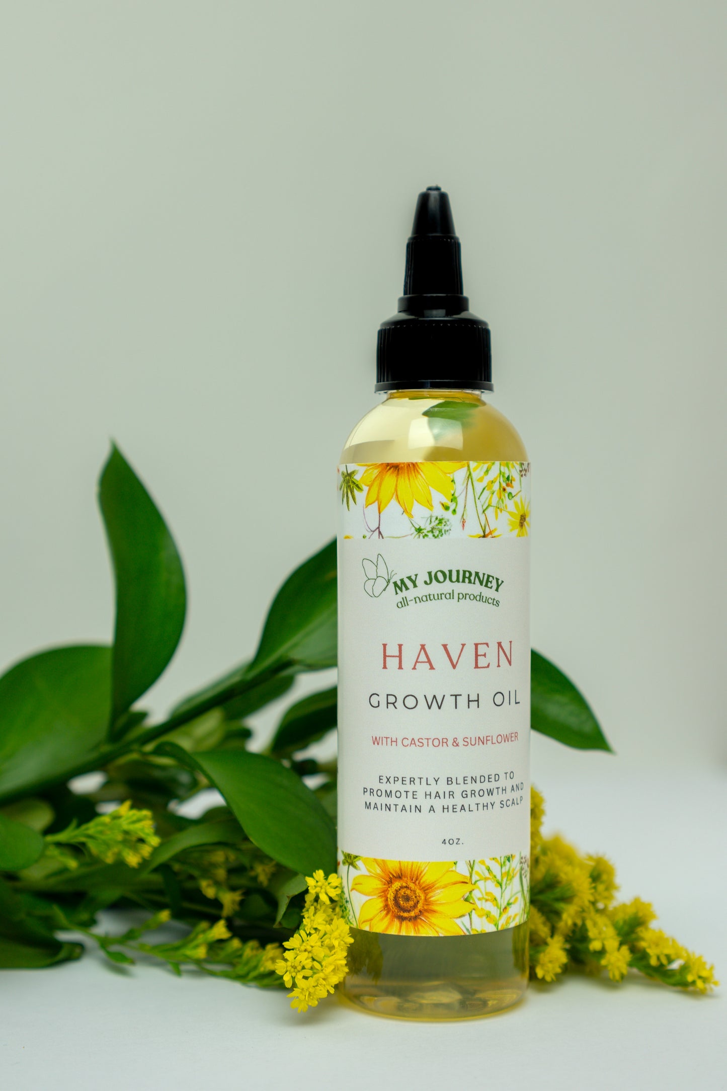 A bottle of Haven Growth Oil with a label that includes sunflowers, indicating it is a hair care product designed to promote hair growth.